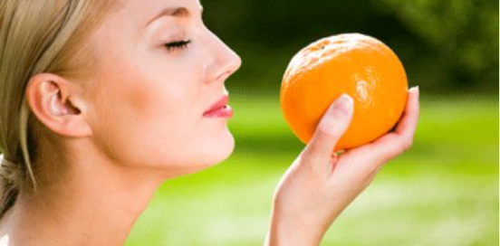 woman smelling an orange