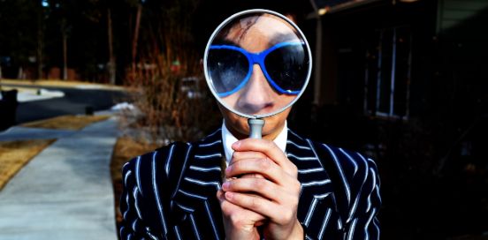 person with magnifying glass on face