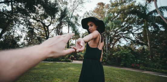 man reaching out to womans hand