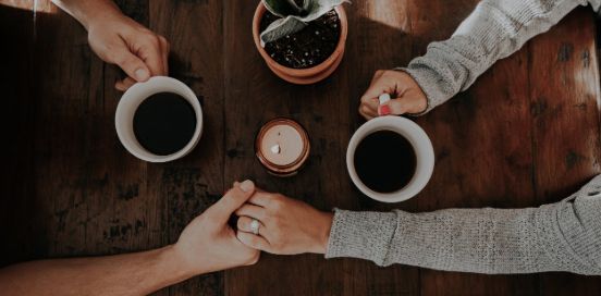 Couple embracing hands and coffee