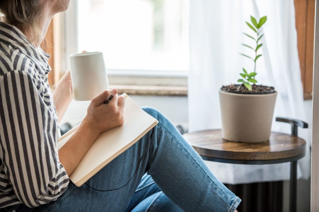Woman drinking tea and journaling
