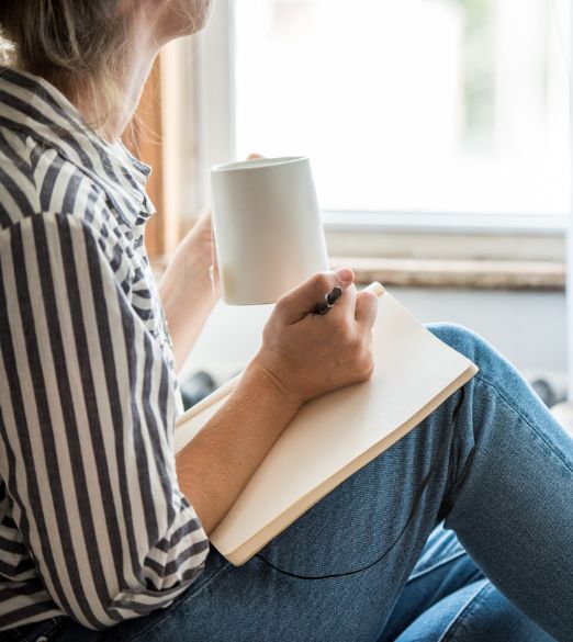 girl journaling and drinking coffee