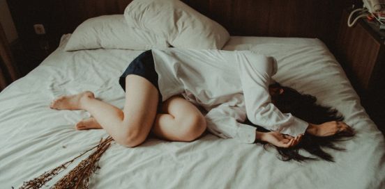 girl in distress laying in bed