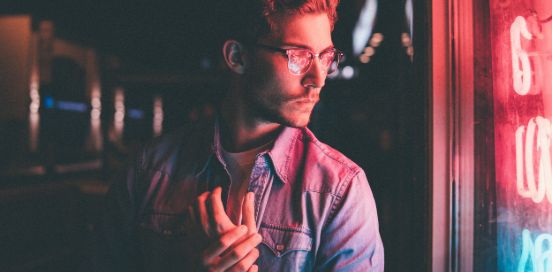 man looking at a store with neon lights