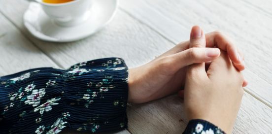 hot tea and clasped hands