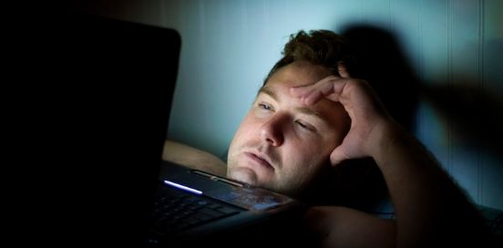 person in bed with laptop