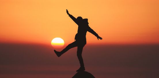 balancing on a rock at sunset