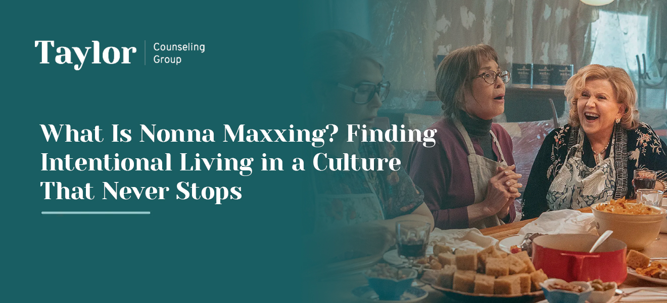 Taylor Counseling Group blog header featuring three older women in aprons laughing and sharing a meal at a table filled with bread and pasta, titled "What Is Nonna Maxxing? Finding Intentional Living in a Culture That Never Stops."