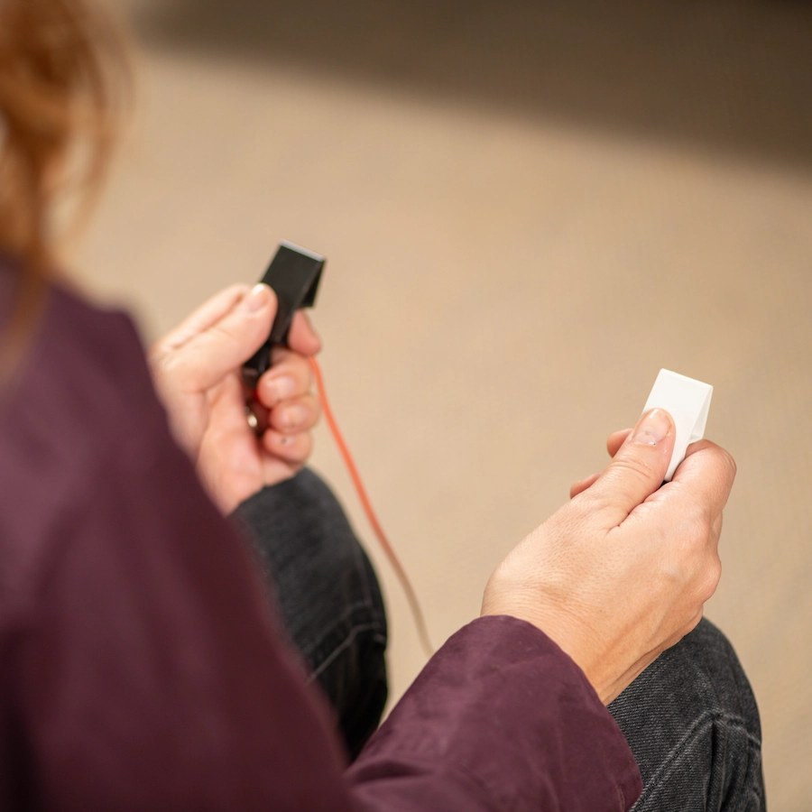 erson holding handheld EMDR therapy devices during a bilateral stimulation session