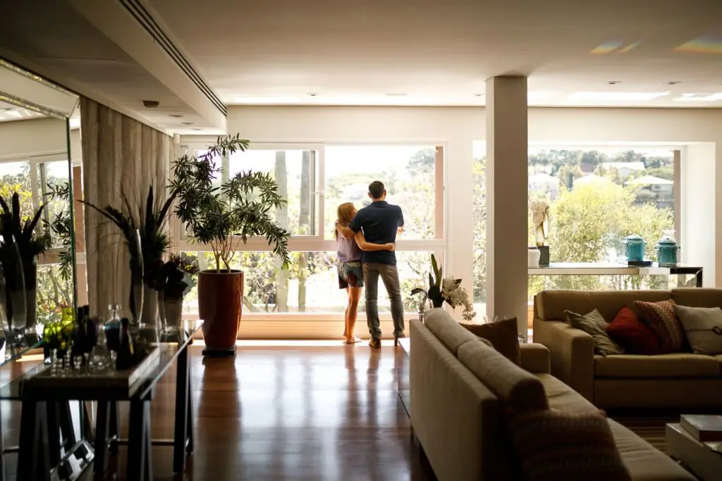Couple admiring the view from the living room of their house.